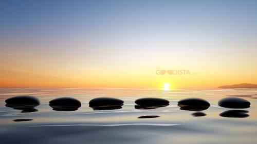 Body, mind and spirit illustrated by sunrise over stones in balance