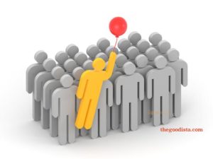 Uniquely able often means being different or standing out from the group illustrated by yellow man holding ballon in a group of grey men.