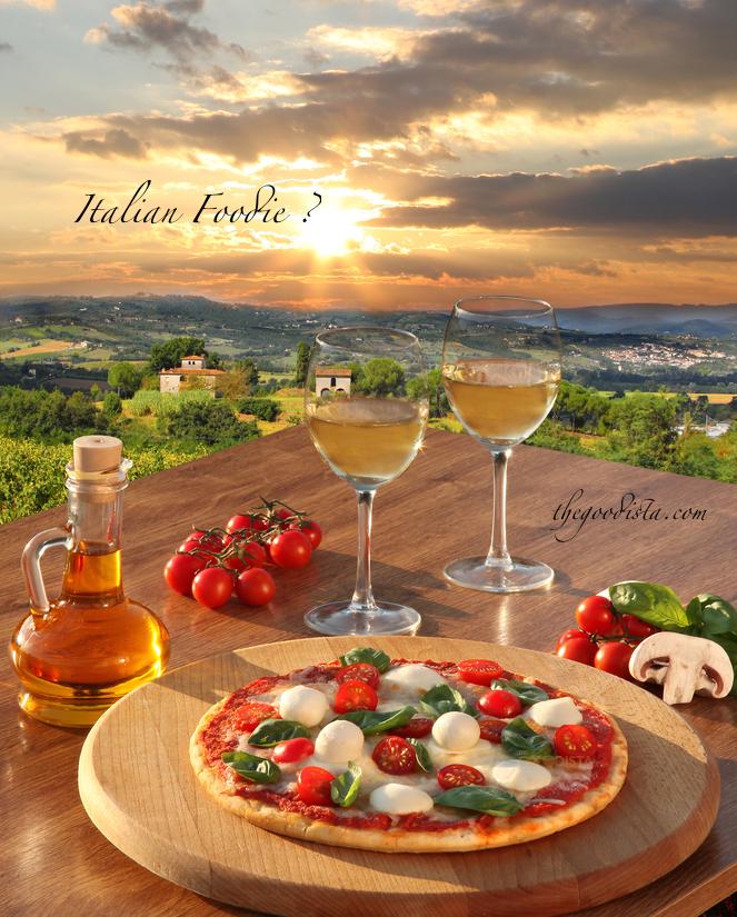 Italian foodie dream with classic pizza wine and olive oil with Chianti landscape in background.