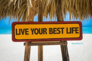 Seize eh day and live your best life, illustrated by sign on beach.